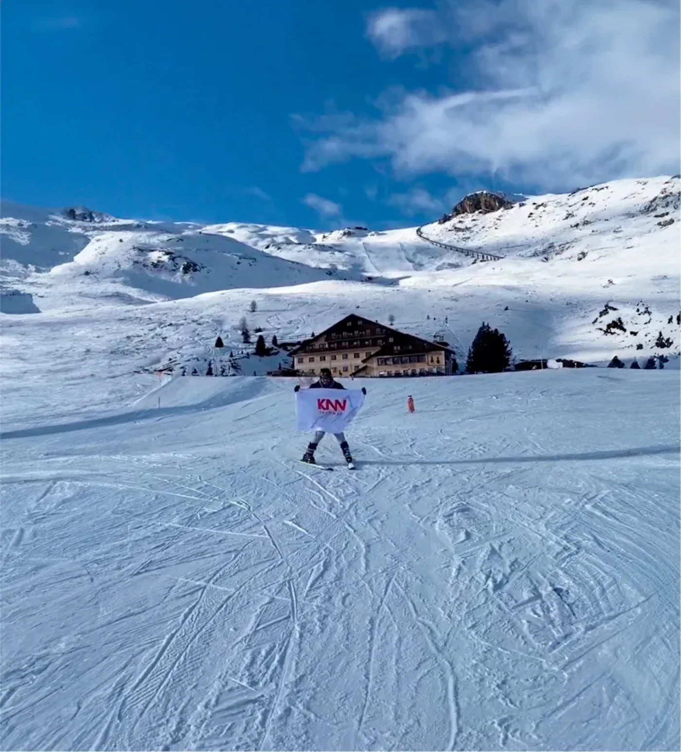 Pessoa com bandeira KNN Idiomas em uma paisagem de neve